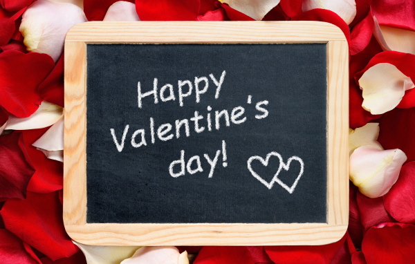 Табличка с надписью С днем Святого Валентина на фоне лепестков роз