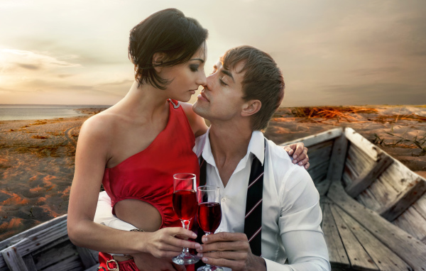 Влюбленная пара сидит в деревянной лодке с бокалами вина