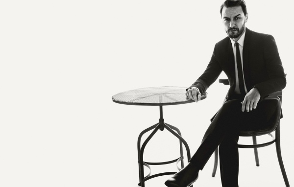 Актер Джеймс Макэвой сидит на стуле за столом черно-белое фото