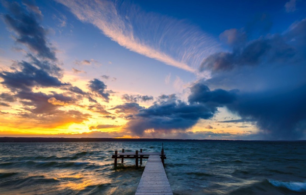 Мост в океане на закате солнца 