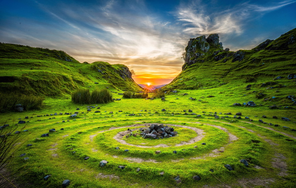 Круги из камней на траве под красивым небом на рассвете