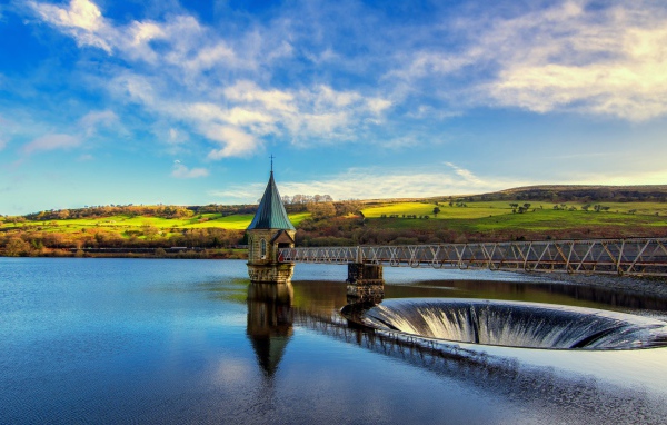 Железный мост над озером под живописным голубым небом 