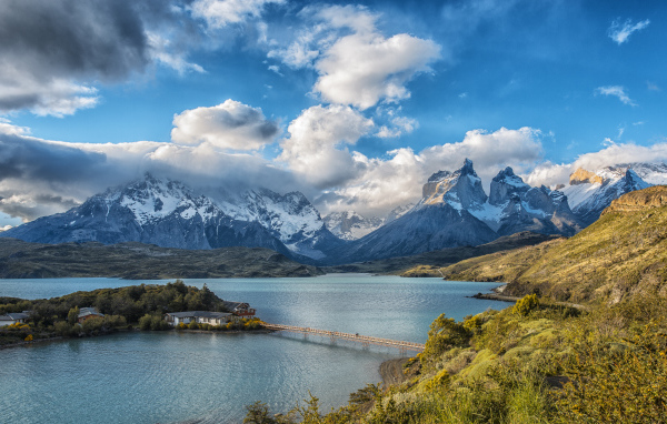 Горы под красивыми белыми облаками у озера в национальном парке Торрес-дель-Пайне, Чили