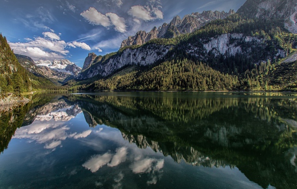 Сосны и горы отражаются в озере  