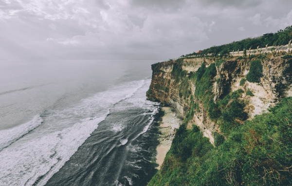 Бушующие волны у зеленого утеса 