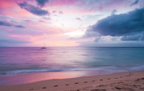 Одинокая яхта на фоне рассветного горизонта 