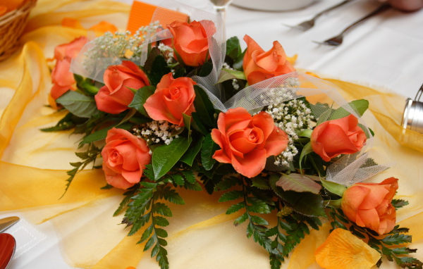 Красивый букет оранжевых роз с зелеными листьями