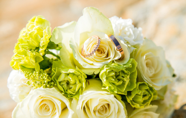 Букет из белых роз с гвоздиками и обручальными кольцами