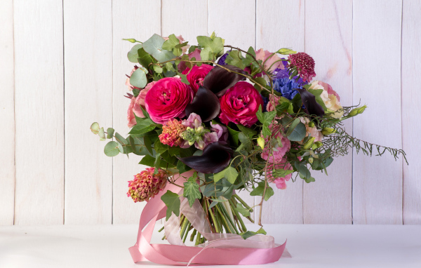 Праздничный букет с розовыми лентами на столе