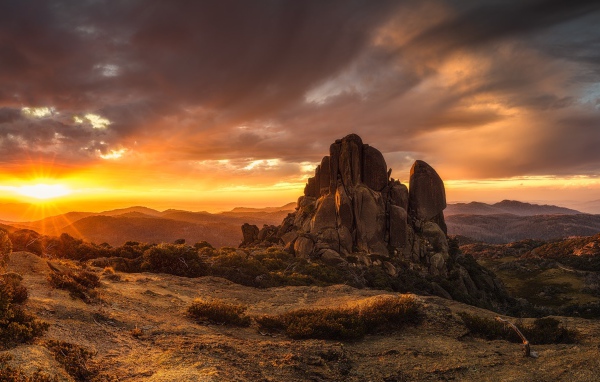 Скала в лучах восходящего солнца 