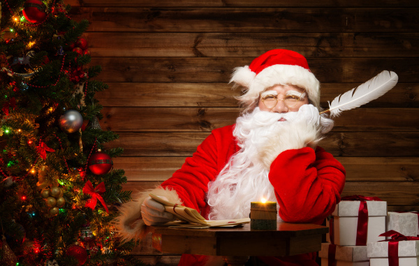Дед Мороз читает письма у новогодней елки