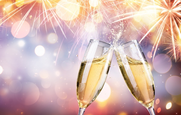 Два бокала с шампанским под праздничным салютом