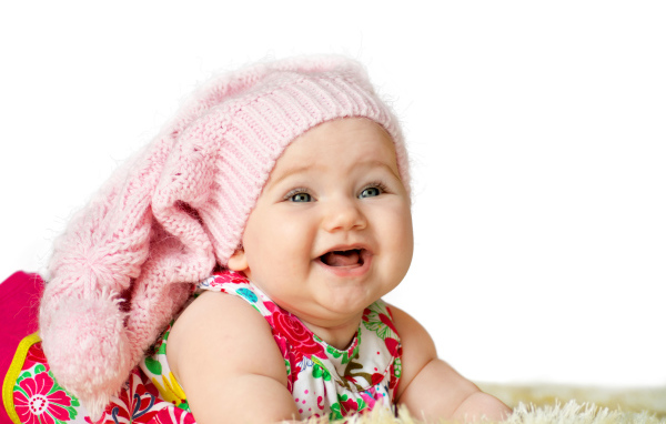 Милая маленькая улыбающаяся девочка в большой розовой шапке