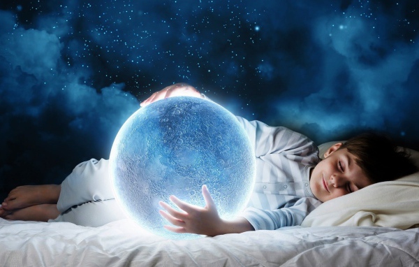 Маленький мальчик во сне держит в руках волшебную голубую луну