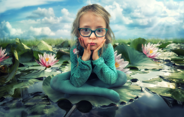 Маленькая девочка в зеленом костюме сидит на листе водяной лилии