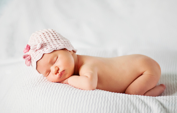 Спящий младенец девочка в розовой шапке