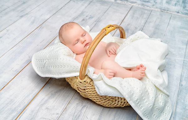 Маленький младенец спит в корзине