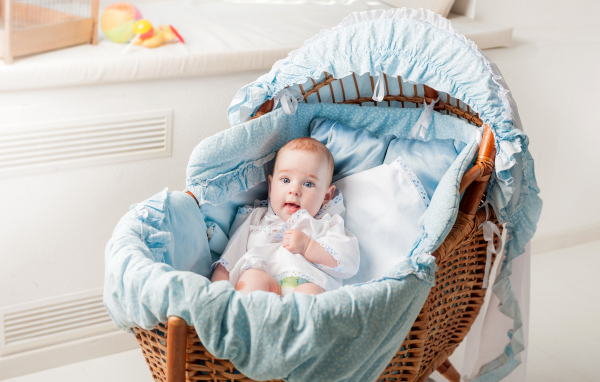 Маленький голубоглазый младенец в кроватке