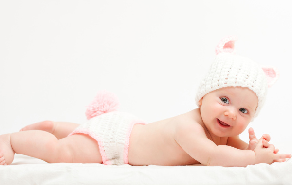 Милый улыбающийся младенец в вязаном костюме