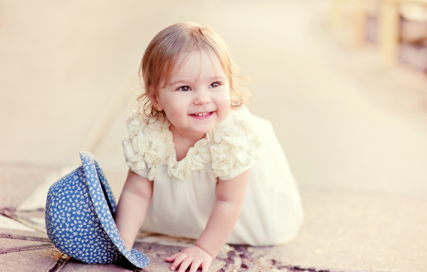 Милая улыбающаяся девочка в белом платье