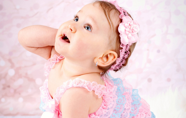 Заинтересованный взгляд маленькой девочки в красивом платье