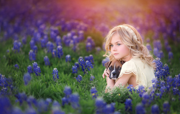 Маленькая светловолосая девочка со щенком в синих цветах
