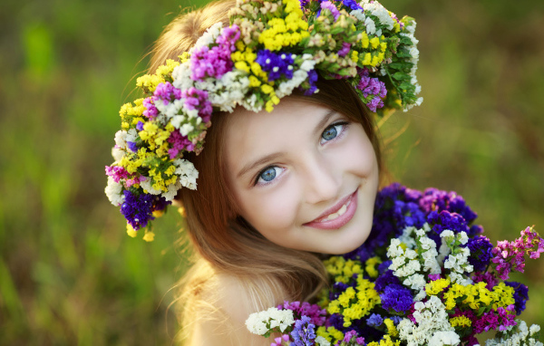 Маленькая голубоглазая девочка с полевыми цветами 