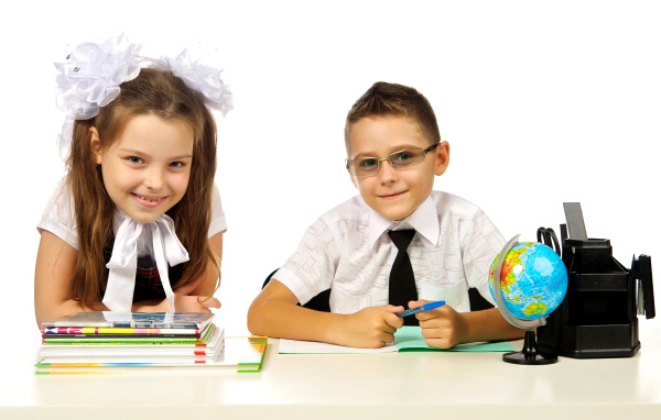 Маленькие мальчик и девочка школьники на белом фоне