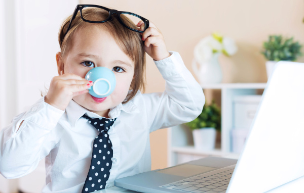 Маленький мальчик в деловом костюме и с чашкой