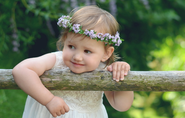 Маленькая кареглазая девочка с венком на голове