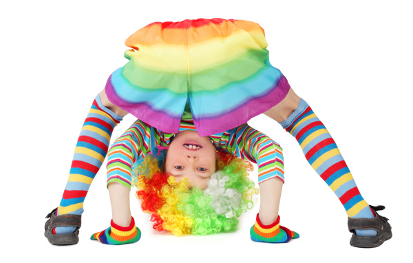 Маленькая смешная девочка в костюме клоуна на белом фоне