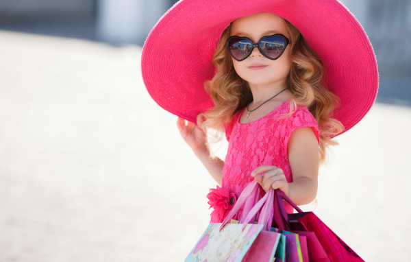 Маленькая девочка модница в большой розовой шляпе