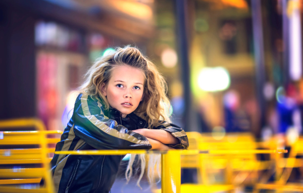 Длинноволосая девочка сидит на карусели