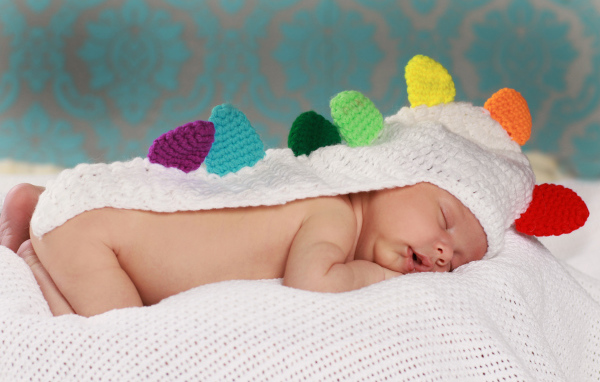 Спящий младенец в белой вязаной накидке