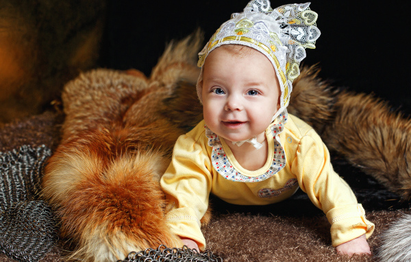 Улыбающаяся голубоглазая девочка в шапке