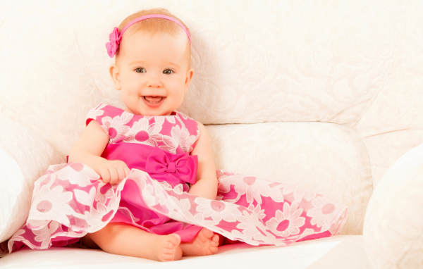 Улыбающаяся маленькая девочка в красивом розовом платье