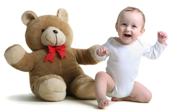 Улыбающийся малыш с большим плюшевым медведем на белом фоне