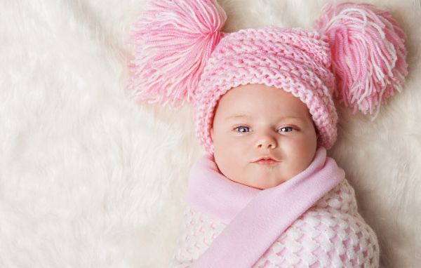 Милая малышка в красивой розовой шапке 