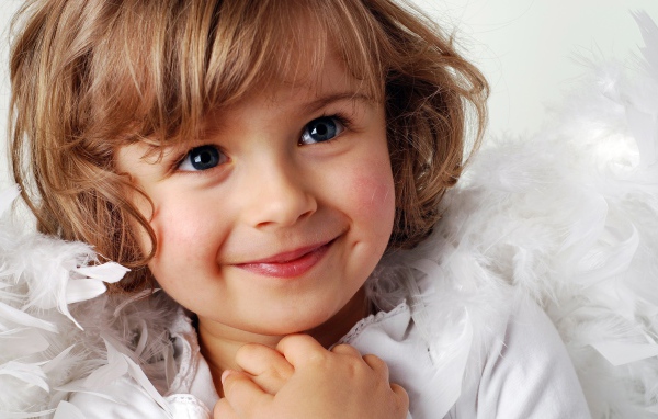 Маленькая голубоглазая девочка в костюме ангела 