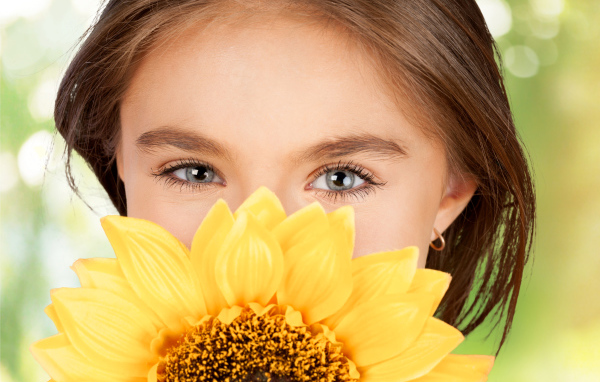 Взгляд маленькой девочки шатенки с подсолнухом в руках