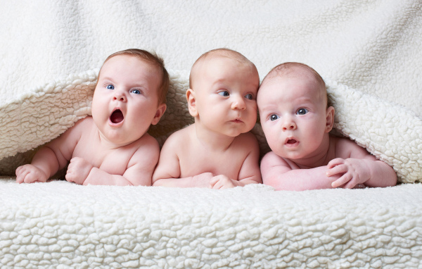 Три младенца под белым теплым одеялом
