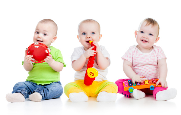 Три улыбающихся младенца играют на белом фоне
