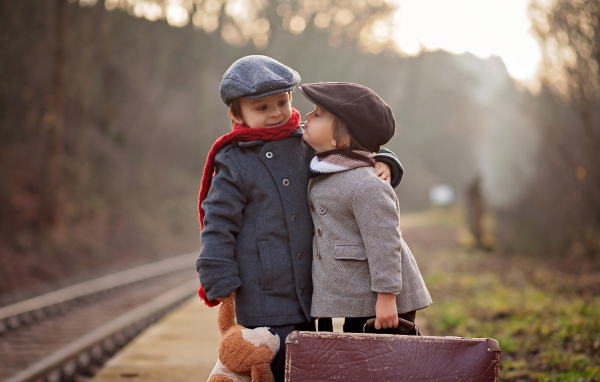 Два мальчика с большим чемоданом у железной дороги