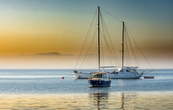 Большая парусная яхта и катер в море