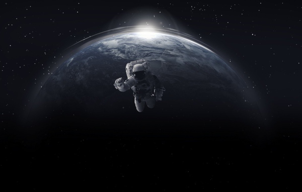 Astronaut in open space against the backdrop of the planet earth