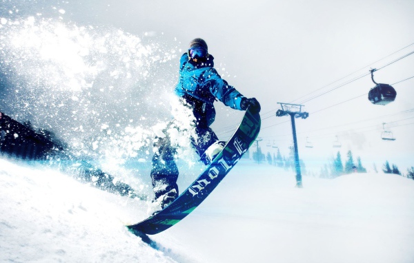 Спортсмен сноубордист на заснеженном склоне горы 