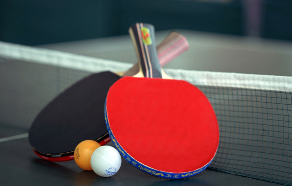 Ракетки для настольного тенниса и мячи на столе  