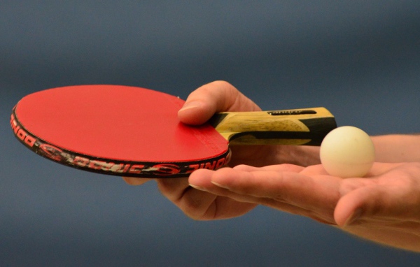Ракетка для настольного тенниса и мяч в руке 
