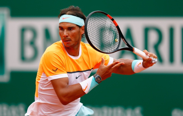 Теннисист Рафаэль Надаль с ракеткой на корте 