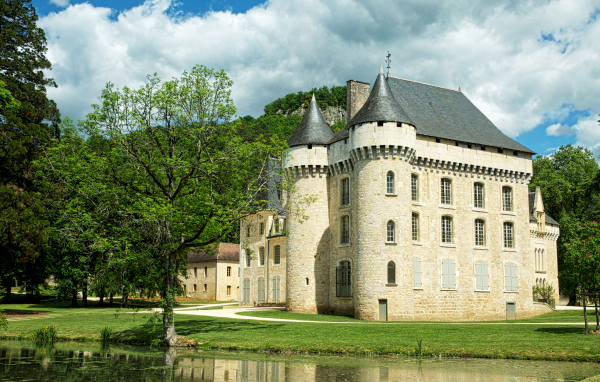 Старинный замок у пруда в зеленом саду, Франция